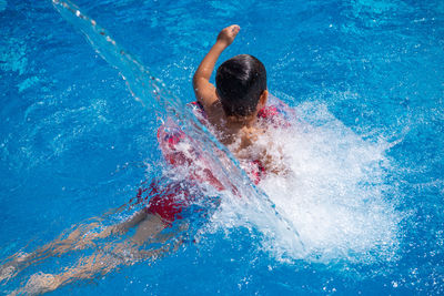 High angle view of boy swimming in pool