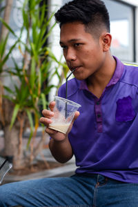 Young man drinking glass on table