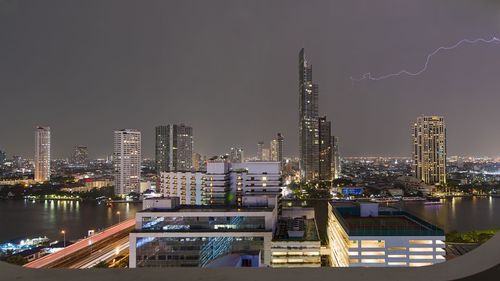 Illuminated buildings in city against sky at night. the silom neighborhood in bangkok, thailand. 