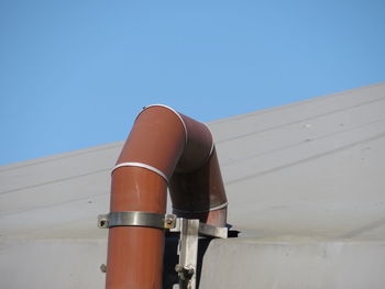 Low angle view of pipe against clear blue sky