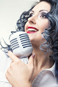 Close-up of beautiful woman wearing mask against white background