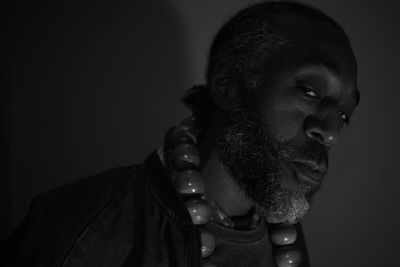 Close-up portrait of young man against black background