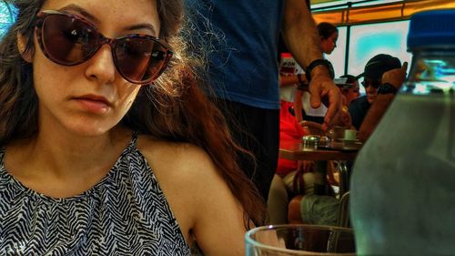 Portrait of young woman wearing sunglasses at restaurant