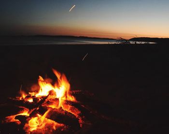 Close-up of bonfire at beach during sunset