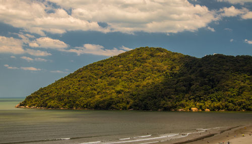 Scenic view of mountain by sea against sky