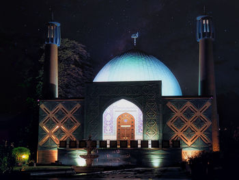 Illuminated building against sky at night