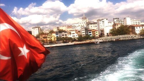 Sea by buildings against sky in city