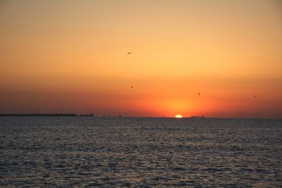 Scenic view of sea against romantic sky at sunset