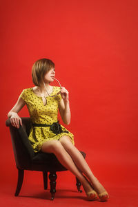 Woman sitting with red umbrella