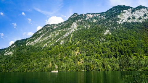 Scenic view of lake by mountains against sky