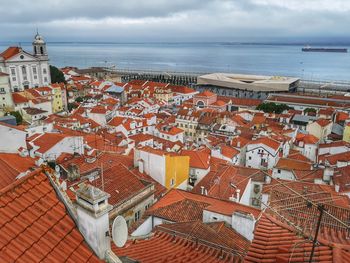 High angle view of townscape by sea against sky