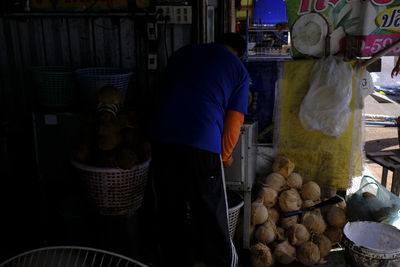 Man working in basket for sale at market stall