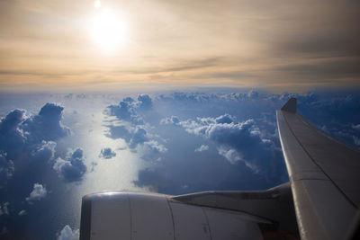 Airplane wing against sky during sunset