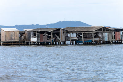 Houses by sea against sky