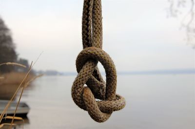 Rope knotted hanging from the top against the background of the lake