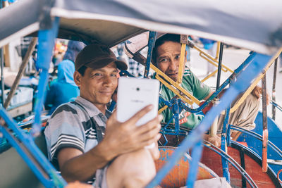 Men taking selfie sitting in land vehicle