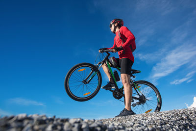 Low angle view of man riding bicycle on mountain