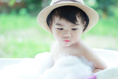 Close-up of shirtless baby in bathtub