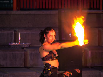 Portrait of young woman holding burning candles