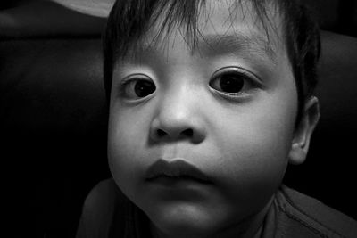 Close-up portrait of cute boy on sofa