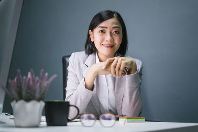 Portrait of a smiling young woman sitting on table