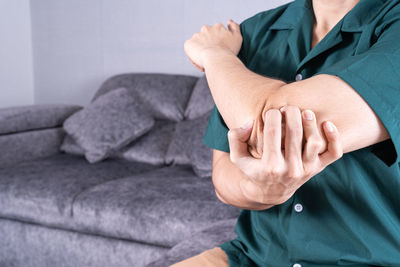 Midsection of man suffering from elbow pain