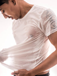 Midsection of woman standing against white background