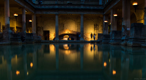 Reflection of illuminated building in water at night