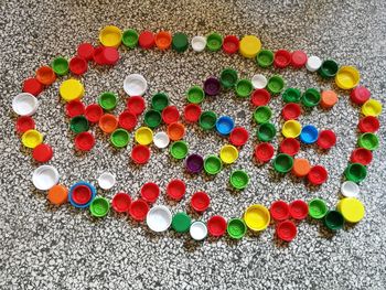High angle view of multi colored bottle caps on floor