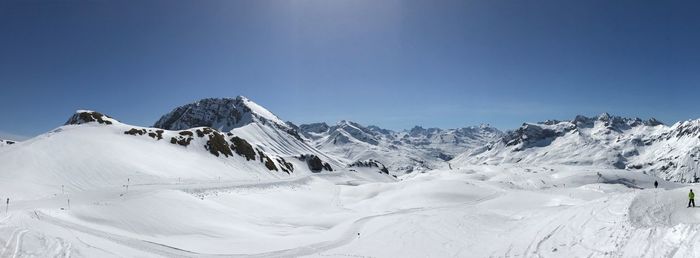 Scenic view of snowcapped mountains against clear blue sky