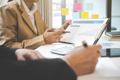 Midsection of businessman using laptop at office