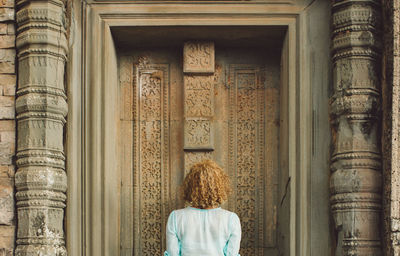 Rear view of woman against closed door