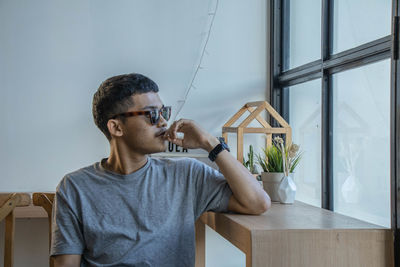 Portrait of young man sitting at home