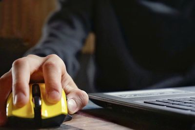 Midsection of man using laptop on desk