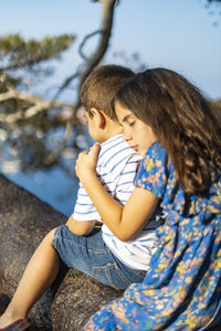 Mother and girl sitting outdoors