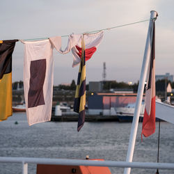 Close-up of flags hanging against boat in sea