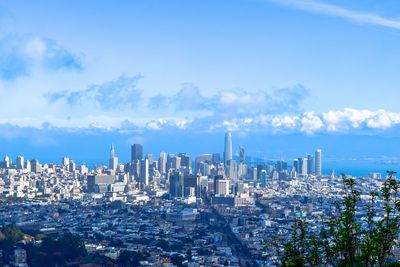 View of cityscape against cloudy sky