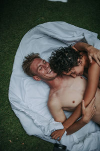 Midsection of a smiling young woman lying on bed