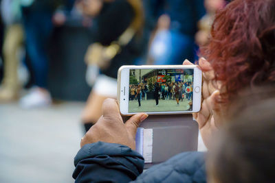 Midsection of woman photographing with mobile phone