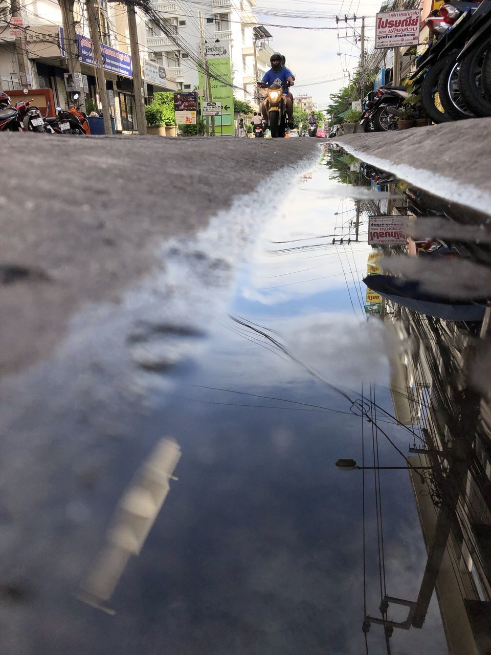 REFLECTION OF BUILDINGS ON PUDDLE