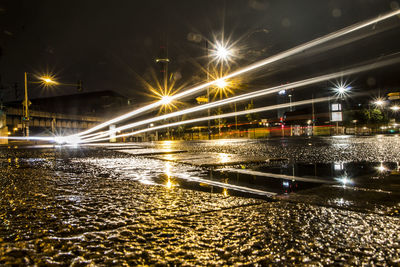 Illuminated light trails in city against sky at night