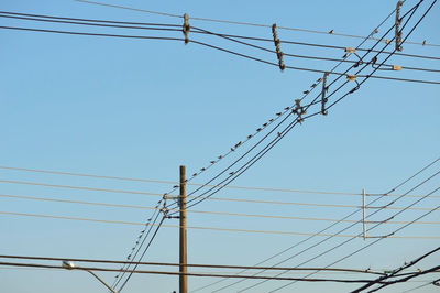 Low angle view of electricity pylon against clear sky