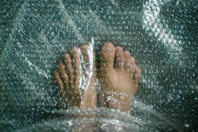 Close-up of wet hand in swimming pool