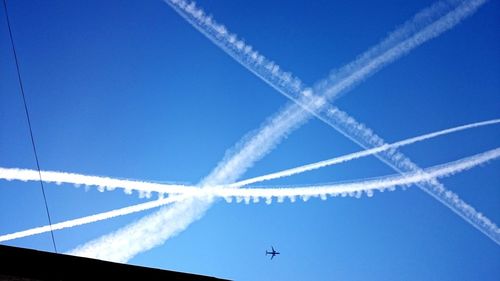 Low angle view of vapor trail against blue sky