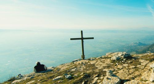 Man on cross against sky