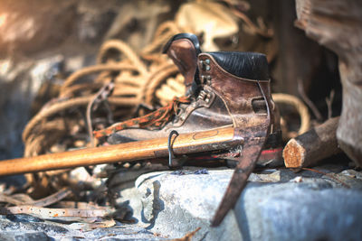 Close-up of work tool and shoe on land