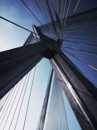 Low angle view of suspension bridge against sky