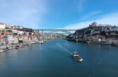 Bridge over river in city against sky