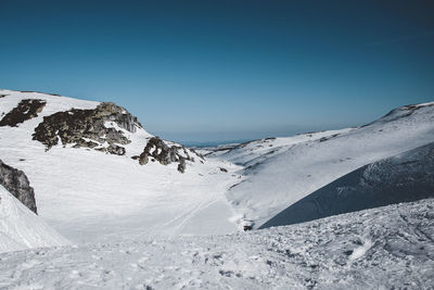 Scenic view of snowcapped mountains against clear blue sky