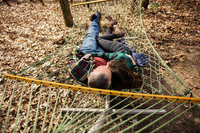 Above view of man and woman embracing lying down in hammock in fall